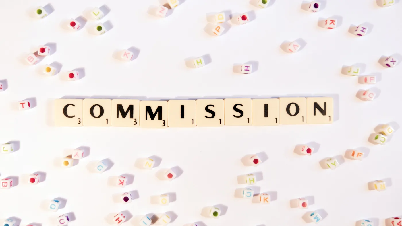 白い机の上に、文字のコマで「COMMISSION」と並べてある