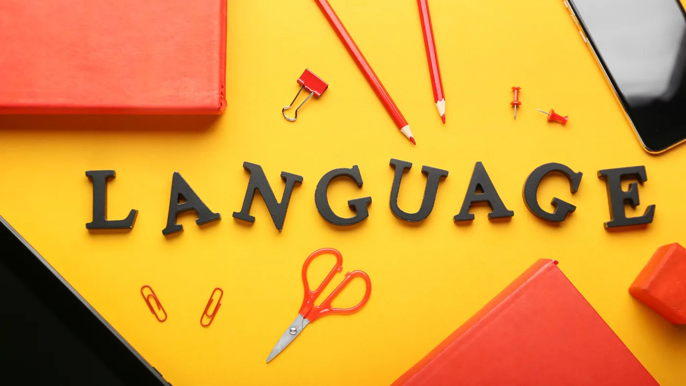黄色い机の上に LANGUAGE の文字を並べた写真