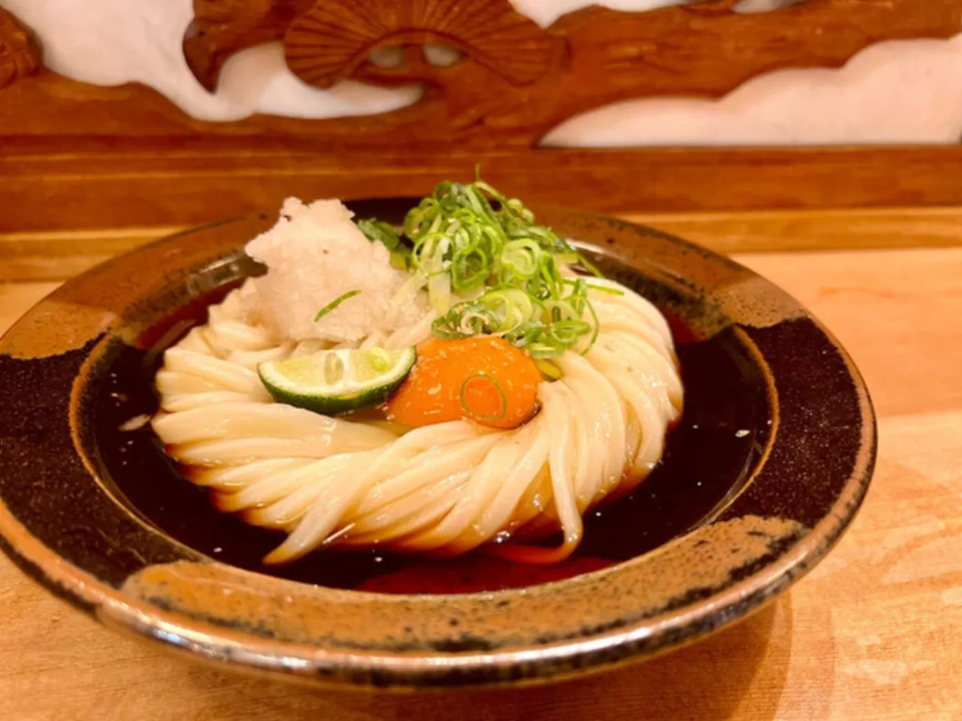 麺散のうどん。器に盛ったうどんに、大根おろし・ねぎ・すだち・卵黄がのっている