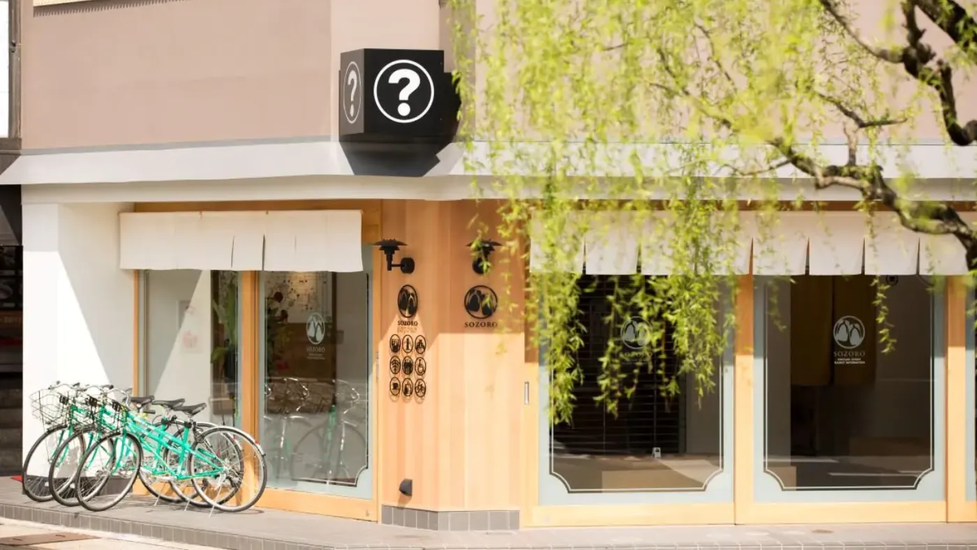 自転車が並ぶ案内所の外観。軒先に「？」の案内の看板