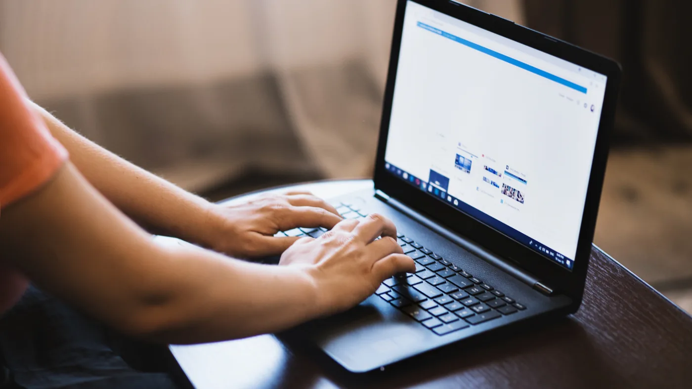 ノートパソコンで予約サイトの商品一覧を開いて操作している手元