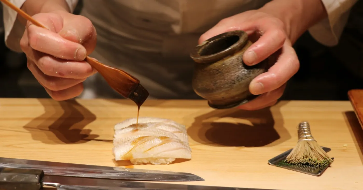 刺身に煮切りを塗る板前の手元