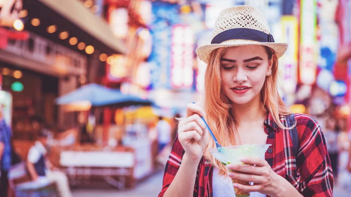 商店街で食べ歩きをしている外国人旅行者
