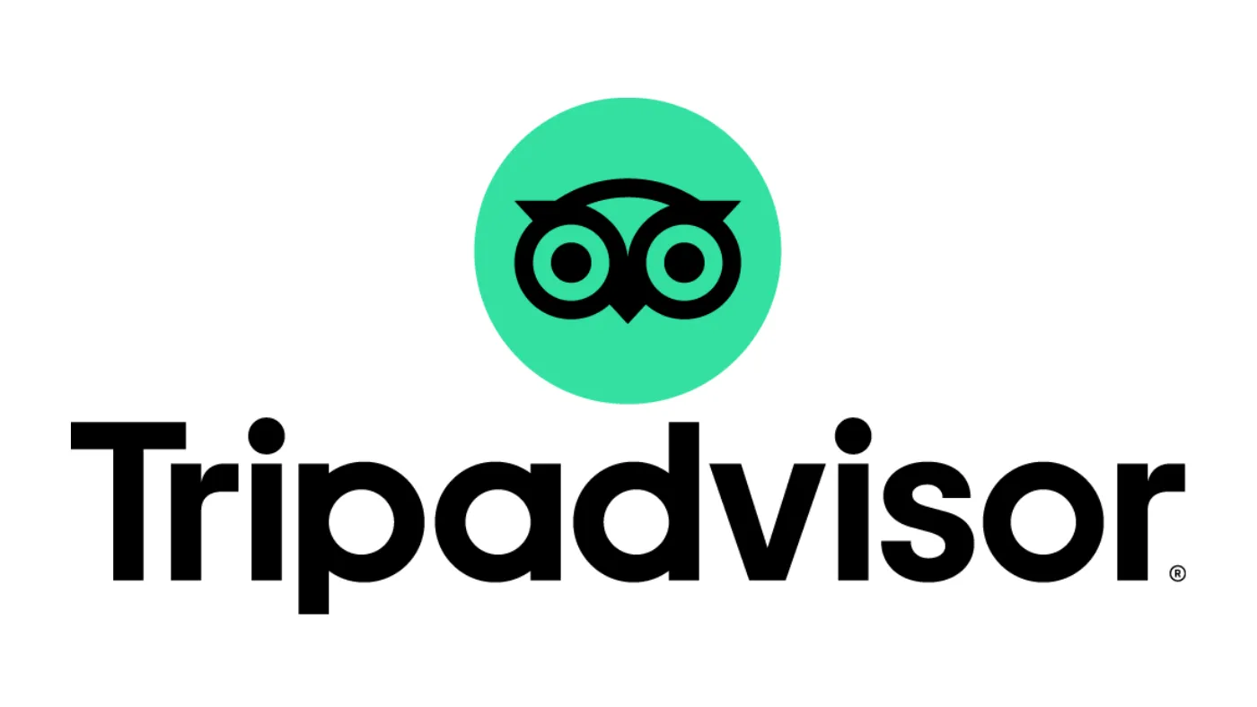 白い背景に、緑の丸の中にフクロウの目の印と、黒い文字で書かれたTripadvisorのロゴ